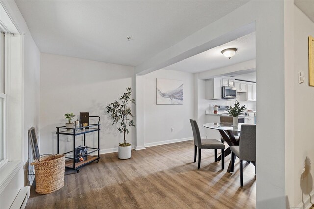 34 Pleasant St Unit 6, Plainfield, CT 06374 - dining room with wood finished floors, a baseboard radiator, and baseboards