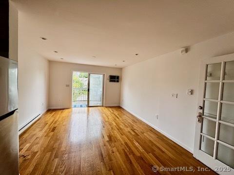 133 Main St Apt 4, Norwalk, CT 06851 - unfurnished room featuring baseboard heating and wood finished floors