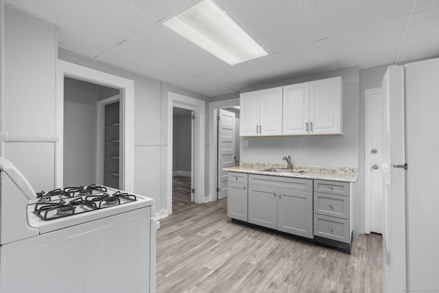108 Highland Ave, Waterbury, CT 06708 - kitchen with white appliances, a sink, a paneled ceiling, light countertops, and gray cabinetry