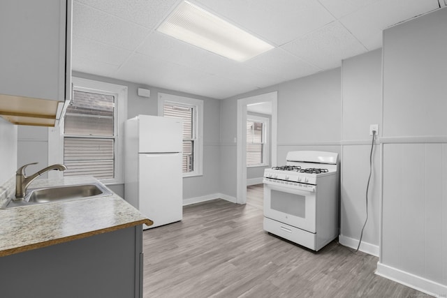 108 Highland Ave, Waterbury, CT 06708 - kitchen with white appliances, a sink, a drop ceiling, light wood-style floors, and baseboards