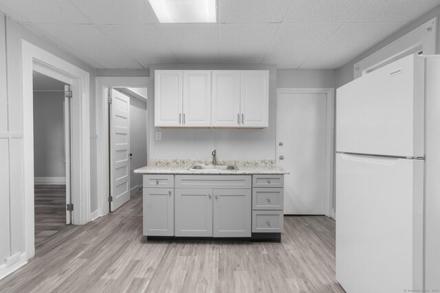108 Highland Ave, Waterbury, CT 06708 - kitchen with freestanding refrigerator, a sink, light countertops, light wood-style floors, and a drop ceiling