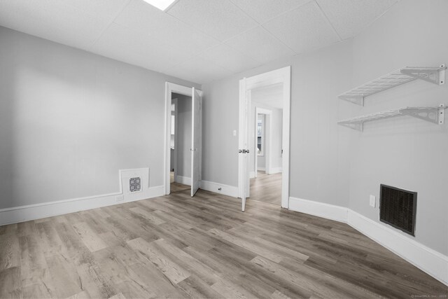 108 Highland Ave, Waterbury, CT 06708 - unfurnished living room with wood finished floors, baseboards, and a drop ceiling