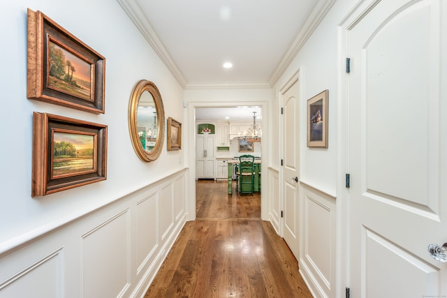 37 Salisbury Rd, Darien, CT 06820 - hallway with a decorative wall, a wainscoted wall, ornamental molding, wood finished floors, and a chandelier