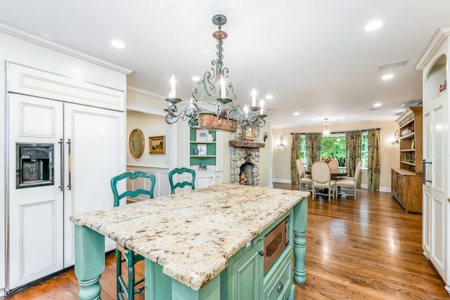 37 Salisbury Rd, Darien, CT 06820 - kitchen with green cabinets, built in appliances, ornamental molding, a center island, and a breakfast bar
