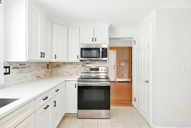 5 Crabapple Rd, Windsor, CT 06095 - kitchen featuring appliances with stainless steel finishes, baseboard heating, tasteful backsplash, light tile patterned floors, and white cabinetry