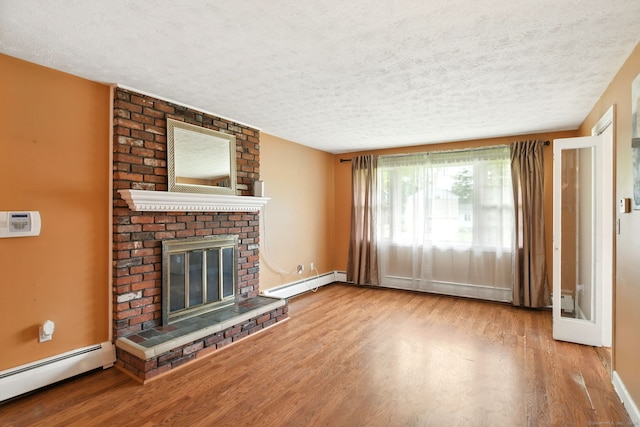 5 Crabapple Rd, Windsor, CT 06095 - unfurnished living room with baseboard heating, a textured ceiling, wood finished floors, a brick fireplace, and baseboards