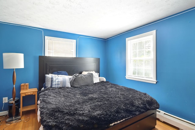 5 Crabapple Rd, Windsor, CT 06095 - bedroom with baseboard heating, wood finished floors, baseboards, and a textured ceiling