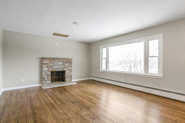 24 Manning St, New Fairfield, CT 06812 - unfurnished living room featuring a baseboard heating unit, wood finished floors, baseboards, and a stone fireplace