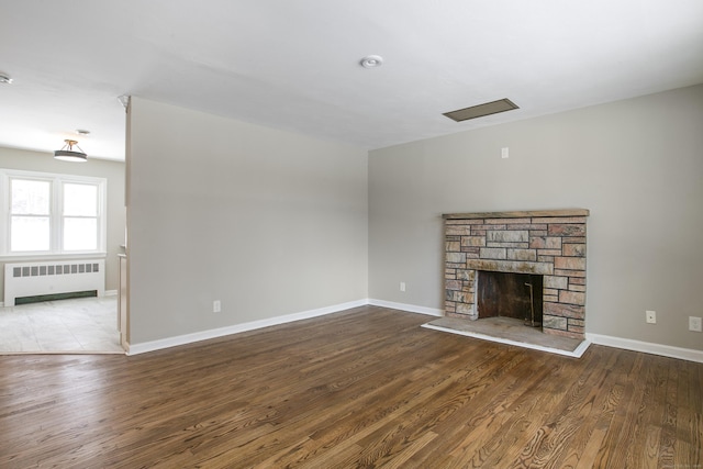 24 Manning St, New Fairfield, CT 06812 - unfurnished living room featuring radiator heating unit, a stone fireplace, wood finished floors, and baseboards