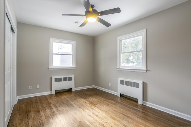 24 Manning St, New Fairfield, CT 06812 - unfurnished bedroom with radiator heating unit, multiple windows, and wood finished floors