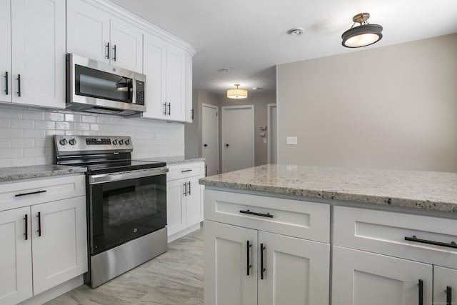 24 Manning St, New Fairfield, CT 06812 - kitchen featuring stainless steel appliances, decorative backsplash, white cabinetry, and light stone countertops