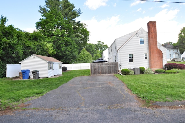 89 Bigelow St, Manchester, CT 06040 - view of side of home with driveway, a chimney, central AC unit, and an outdoor structure