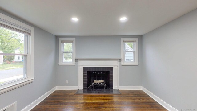 77 Hemlock St, Manchester, CT 06040 - unfurnished living room featuring dark wood-style flooring, a brick fireplace, plenty of natural light, and recessed lighting