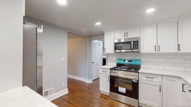 77 Hemlock St, Manchester, CT 06040 - kitchen with stainless steel appliances, baseboards, light countertops, dark wood-style floors, and tasteful backsplash