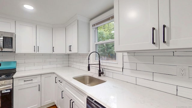 77 Hemlock St, Manchester, CT 06040 - kitchen featuring stainless steel appliances, a sink, white cabinets, and backsplash