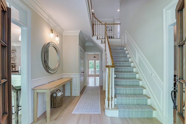 68 Topstone Rd, Ridgefield, CT 06877 - staircase featuring crown molding, a decorative wall, wood finished floors, and a wainscoted wall