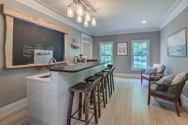68 Topstone Rd, Ridgefield, CT 06877 - kitchen with a sink, baseboards, light wood-type flooring, a breakfast bar area, and crown molding