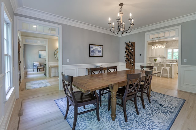 68 Topstone Rd, Ridgefield, CT 06877 - dining area featuring a chandelier, crown molding, light wood-type flooring, wainscoting, and a decorative wall