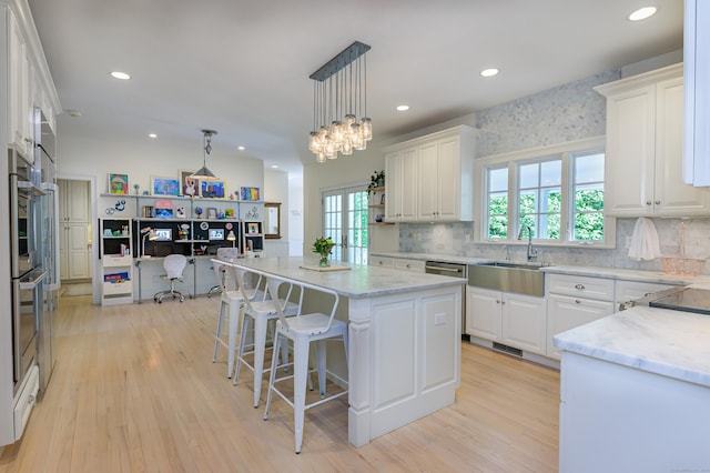 68 Topstone Rd, Ridgefield, CT 06877 - kitchen with a sink, white cabinetry, a center island, light wood-style flooring, and recessed lighting