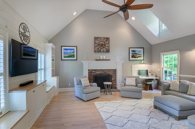 68 Topstone Rd, Ridgefield, CT 06877 - living room with a fireplace, light wood-style floors, high vaulted ceiling, a skylight, and ceiling fan