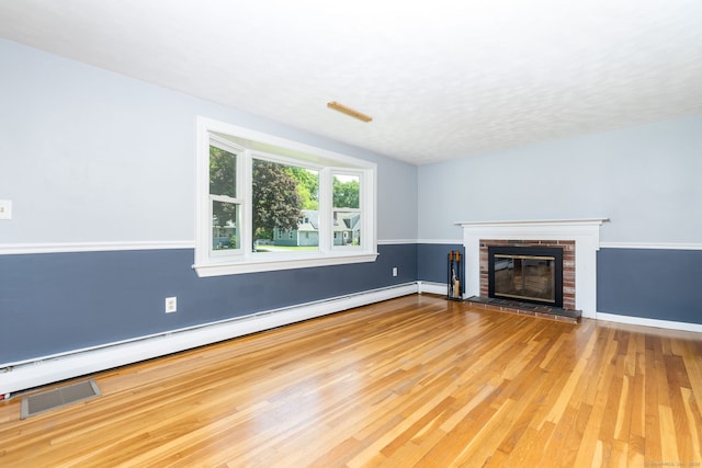 10 Cartier Rd, Enfield, CT 06082 - unfurnished living room with a baseboard heating unit, wood finished floors, a fireplace, and baseboards