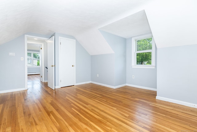 10 Cartier Rd, Enfield, CT 06082 - additional living space with vaulted ceiling, light wood-style flooring, healthy amount of natural light, baseboard heating, and baseboards
