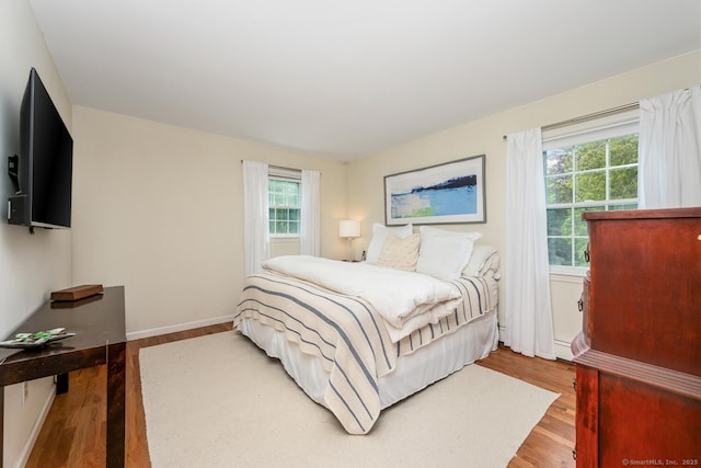 290 Fillow St, Norwalk, CT 06850 - bedroom with wood finished floors, baseboards, and a baseboard heating unit