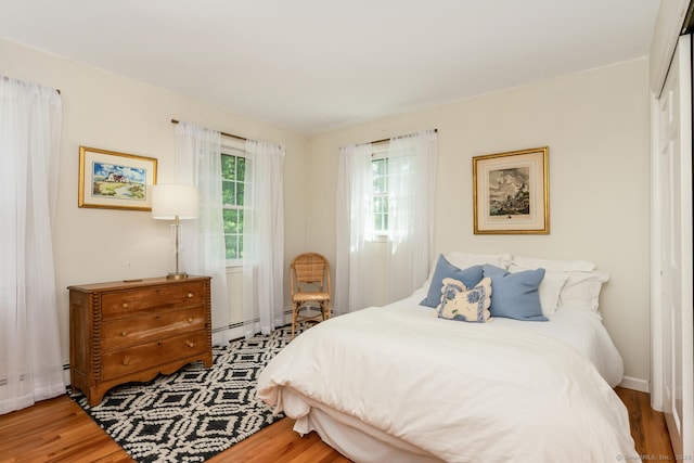 290 Fillow St, Norwalk, CT 06850 - bedroom with wood finished floors, baseboard heating, and baseboards