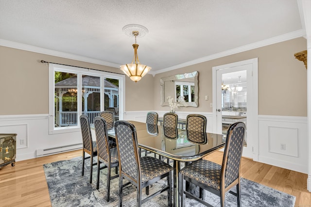 48 Shepherds Trl, Madison, CT 06443 - dining area with a baseboard heating unit, a chandelier, wainscoting, crown molding, and light wood-style flooring
