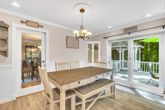 48 Shepherds Trl, Madison, CT 06443 - dining room with a chandelier, light wood-type flooring, crown molding, a wainscoted wall, and a textured ceiling