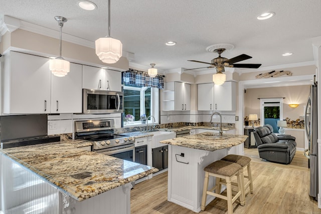 48 Shepherds Trl, Madison, CT 06443 - kitchen featuring appliances with stainless steel finishes, a textured ceiling, a sink, ornamental molding, and a peninsula