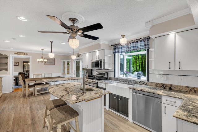 48 Shepherds Trl, Madison, CT 06443 - kitchen with appliances with stainless steel finishes, a sink, a kitchen island with sink, light wood-style floors, and white cabinets