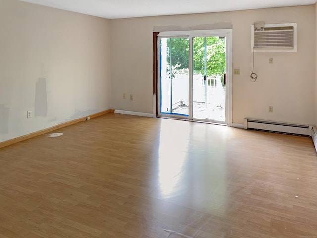245 E Woodland St Apt 14, Meriden, CT 06451 - spare room with an AC wall unit, light wood-style flooring, baseboards, and a baseboard radiator