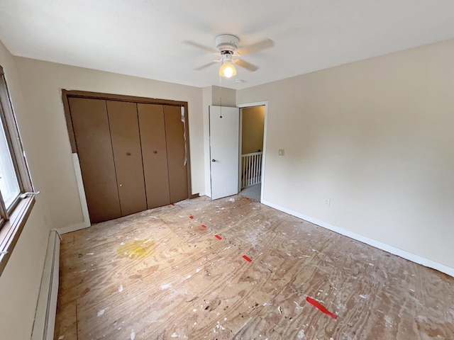 245 E Woodland St Apt 14, Meriden, CT 06451 - unfurnished bedroom with baseboard heating, a closet, and a ceiling fan