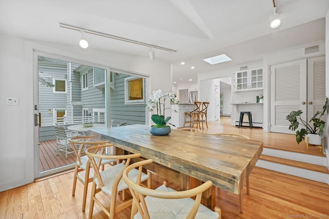 32 Jeffrey Rd, Greenwich, CT 06830 - dining room featuring track lighting, a baseboard radiator, a skylight, light wood-type flooring, and recessed lighting