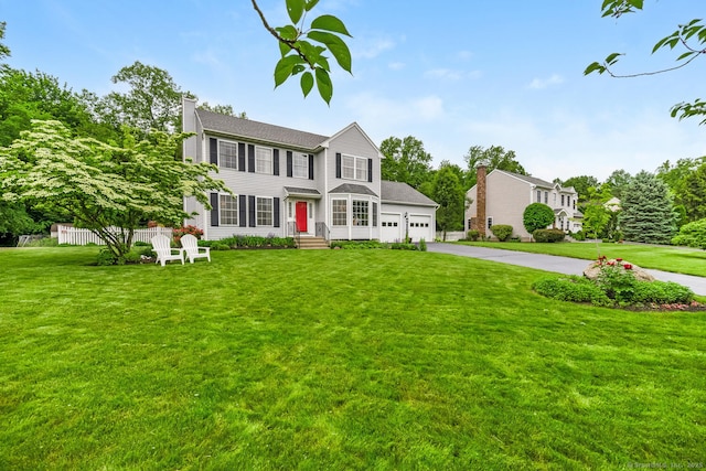 125 Longview Dr, Stratford, CT 06614 - colonial-style house with asphalt driveway, a chimney, a front lawn, and a garage