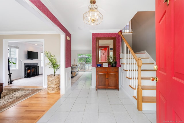 125 Longview Dr, Stratford, CT 06614 - entryway with stairs, a chandelier, crown molding, a fireplace with flush hearth, and baseboards