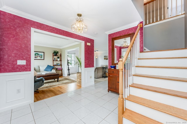 125 Longview Dr, Stratford, CT 06614 - foyer entrance featuring a chandelier, a wainscoted wall, stairs, crown molding, and light tile patterned floors