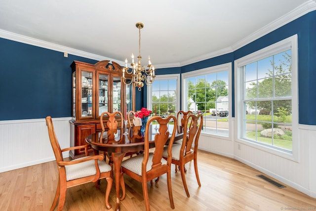 125 Longview Dr, Stratford, CT 06614 - dining area featuring a chandelier, light wood finished floors, healthy amount of natural light, a wainscoted wall, and crown molding