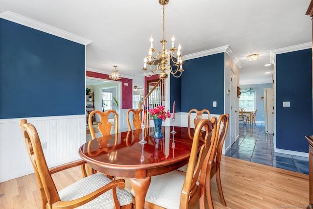 125 Longview Dr, Stratford, CT 06614 - dining area featuring plenty of natural light, ornamental molding, wainscoting, a chandelier, and wood finished floors