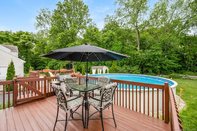 125 Longview Dr, Stratford, CT 06614 - wooden terrace featuring an outdoor pool, outdoor dining area, view of scattered trees, and area for grilling
