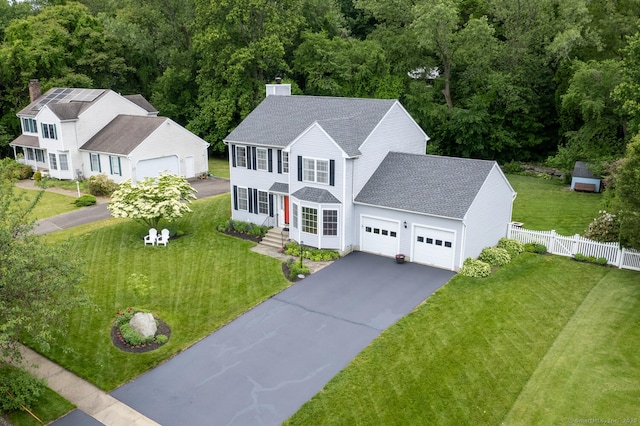 125 Longview Dr, Stratford, CT 06614 - view of front facade with a chimney, a garage, a shingled roof, and driveway