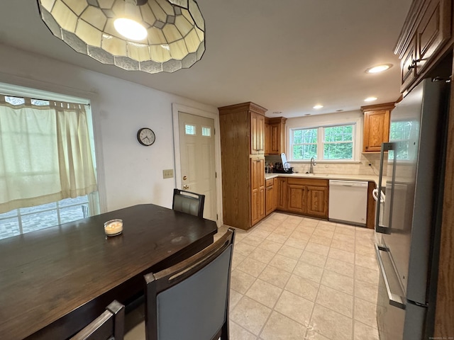 87 Munson Rd, Beacon Falls, CT 06403 - kitchen with dishwasher, freestanding refrigerator, brown cabinetry, light countertops, and light tile patterned floors