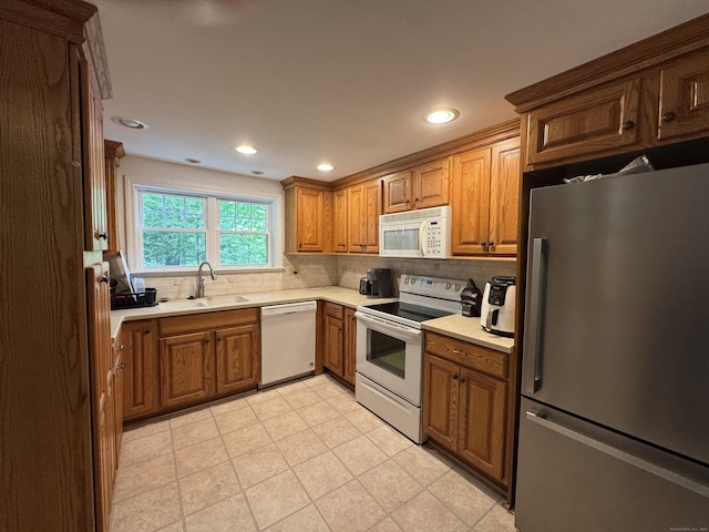 87 Munson Rd, Beacon Falls, CT 06403 - kitchen with white appliances, a sink, decorative backsplash, brown cabinetry, and light countertops