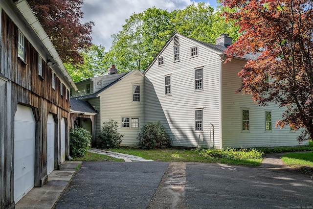 8 Southbury Rd, Roxbury, CT 06783 - view of property exterior featuring a garage, a chimney, and asphalt driveway