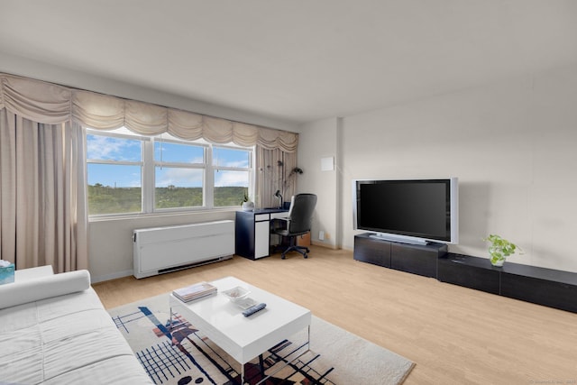 2625 Park Ave Unit 7R, Bridgeport, CT 06604 - living room with radiator, wood finished floors, a desk, and baseboards