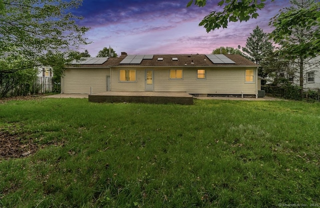 24 Linde St, West Haven, CT 06516 - back of property at dusk featuring a patio area and roof mounted solar panels