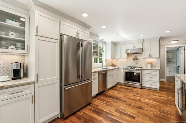 8 Buttonwood Dr, Simsbury, CT 06070 - kitchen featuring appliances with stainless steel finishes, under cabinet range hood, backsplash, dark wood-style flooring, and glass insert cabinets