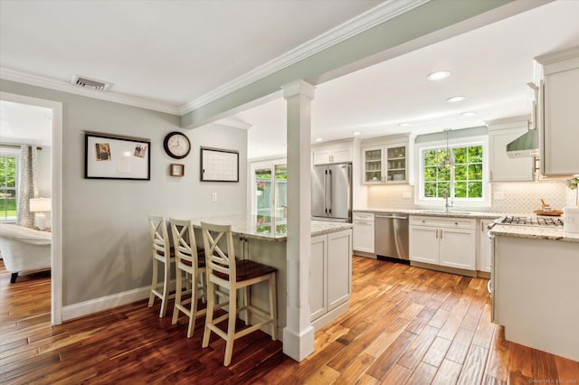8 Buttonwood Dr, Simsbury, CT 06070 - kitchen featuring stainless steel appliances, plenty of natural light, tasteful backsplash, crown molding, and wood-type flooring