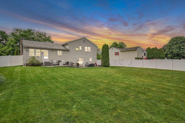 8 High Meadow Ln, Enfield, CT 06082 - back of property at dusk with a chimney and a patio area